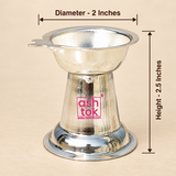 Size guide image of a German Silver Diya on a beige studio background with clear measurement arrows and text, showing the upper bowl diameter as 2 inches and the overall height as 2.5 inches, while also displaying the polished silver finish, shallow bowl design, side wick-holder extension, tapered conical center body and stable circular base, helping customers easily understand the compact product dimensions and proportions before purchase for pooja use, decorative use or gifting.