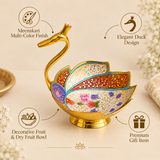 Features infographic of a decorative Meenakari duck design fruit bowl highlighting its multicolor Meenakari finish, elegant duck-shaped design, suitability as a fruit and dry fruit bowl and premium gifting appeal. The product features a graceful curved golden neck and head, layered feather-shaped bowl sections with intricate white, red, blue, turquoise, purple and green floral detailing, polished golden borders and a stable pedestal base.