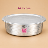 14 inch Aluminium Biryani Handi with Lid featuring a traditional round, wide-mouth cooking vessel with a hammered silver aluminium exterior and a matching flat circular lid. The handi has a smooth rounded base, slightly raised rim and distinctive hand-hammered texture across the outer body. Displayed from the front at a slightly elevated angle against a warm beige studio background with soft lighting and natural shadows.