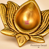 Detailed close-up view of a traditional antique brass lotus diya highlighting its smooth teardrop-shaped oil cavity, raised floral edges, intricately engraved lotus petals and textured golden brass finish. The image showcases the contrasting polished and antique-style surfaces, detailed grooves and decorative craftsmanship of this compact diya for daily puja, Diwali celebrations and traditional home temple arrangements.