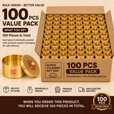 Bulk promotional banner graphic for the Ashtok Alpha Cylinder Gift Box 100 Pcs Value Pack. A large cardboard shipping box is packed densely with 100 round brass gift boxes featuring engraved lids with red central accents. In the lower left foreground, a single brushed brass container is shown open alongside its lid. Text overlays include "BULK ORDER • BETTER VALUE", "100 PCS VALUE PACK", and "100 Pieces in Total", supported by icons indicating bulk quantity, individual packaging, premium quality, and secure
