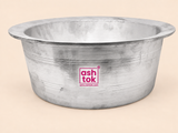 Front-facing product shot of a wide, open silver aluminum mixing bowl with a flared lip rim against a clean beige background. The bowl features fine horizontal line patterns etched around the exterior and a magenta Ashtok logo displayed in the center.