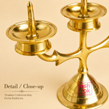 Close-up of Ashtok brass 3-face diya stand showing fine brass metalwork, polished finish, oil cup, and sturdy pedestal base.