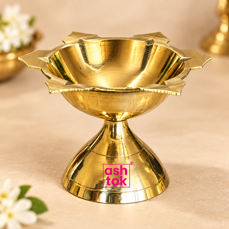 Polished Ashtok brass diya main product image showing a single traditional brass diya with petal edge design and footed base placed on a soft beige background.