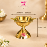 Ashtok brass diya size guide image showing the diya with measurement arrows indicating 2 inch diameter and 1 inch height on a beige background.