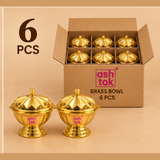 Product packaging view of a 6-piece pack of Ashtok brass kumkum bowls, featuring an open cardboard shipping box with six neatly organized lidded brass containers and two individual golden bowls displayed in front.