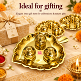 ASHTOK brass leaf shaped kumkum box presented as an elegant traditional gift item, featuring one complete polished brass leaf tray with three matching lidded kumkum boxes displayed prominently with additional matching sets in the background. Styled with a premium gift box, festive flowers, diya lighting, kumkum and haldi accessories, the image demonstrates its suitability for wedding return gifts, housewarming gifts, festive gifting, pooja functions, family celebrations and special occasions.