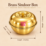 Ashtok Brass Sindoor Box size guide showing the compact traditional brass kumkum and sindoor container with clear measurements of 2 inches length, 2 inches width and 2 inches height. The image displays the round glossy golden brass box with its fitted dome-shaped lid, small central brass knob and original pink Ashtok branding against a premium warm beige background. Measurement arrows clearly demonstrate the approximate overall dimensions to help customers understand the compact size before purchase. This p