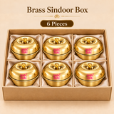Set of 6 Ashtok Brass Sindoor Boxes arranged neatly inside a premium beige gift-style presentation box with individual cushioned compartments. Each compact brass sindoor container features a glossy polished golden finish, rounded bowl-shaped body, fitted dome lid, small central brass knob and clearly visible pink Ashtok logo on the front. The six matching sindoor dabbis are displayed together to represent the 6 piece quantity option, suitable for customers purchasing multiple brass kumkum boxes for wedding 