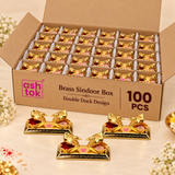 Pack of 100 image of Ashtok brass sindoor box double duck design showing ten brass sindoor boxes neatly packed inside a gift box with compartments, with product branding and elegant presentation suitable for return gifts and festive gifting.