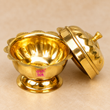 Close-up detail image of ASHTOK brass sindoor box showing the polished golden brass finish, open bowl interior, decorative scalloped rim, footed base and matching lid, highlighting the craftsmanship and premium reflective surface.