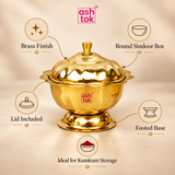 ASHTOK brass sindoor box feature image highlighting the polished brass finish, round storage shape, lid included, footed base and suitability for kumkum storage, presented on a clean beige background with premium product callouts.