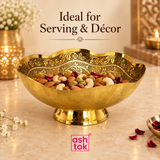 Ashtok Brass Turkish Bowl styled in an elegant lifestyle setting and filled with assorted dry fruits including almonds, cashews, pistachios and raisins, demonstrating how the decorative bowl can be used for serving guests, festive entertaining and premium table presentation. The scalloped brass rim, ornate floral engraved interior, golden pedestal base and traditional handcrafted appearance are showcased against a warm beige décor setting with soft flowers and ambient lighting, making the bowl suitable for 