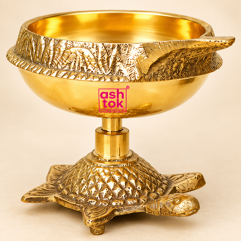 Close-up image of a brass diya with a textured turtle-shaped base, highlighting the polished golden finish, bowl shape, craftsmanship, and intricate detailing on a beige background.