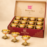 Pack of 12 brass diyas with turtle bases arranged in a branded box display, ideal for festive gifting, pooja events, bulk orders, and traditional ceremonial use.