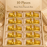 Ten piece gift pack image of the brass twin peacock box displayed in an elegant beige box with individually arranged padded slots. The image shows ten matching traditional brass twin peacock boxes, each with polished golden tone, curved compartment lids, peacock head knobs and ornamental detailing. The set is suitable for larger festive gifting requirements such as wedding favors, pooja ceremony giveaways, family events, return gifts, festival hampers and premium traditional gifting. The refined packaging.