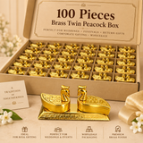 Bulk gifting and wholesale image of the brass twin peacock box showing a large organized carton-style presentation containing many identical pieces arranged in neat compartments, representing the 100 piece quantity option. In the foreground, a single twin peacock box is displayed clearly so customers can see the polished golden brass finish, twin lidded compartments, decorative embossed patterns and traditional peacock form, while the larger box in the background conveys suitability for wholesale supply, we