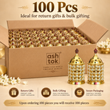 100 Pcs bulk pack image of ASHTOK Crystal Diya Brass showing a large corrugated box filled with multiple carefully packed pieces and sample products displayed outside the box. The image is styled on a warm beige background and emphasizes secure packaging, bulk gifting and return gift suitability. It visually communicates that upon ordering 100 pieces, the customer will receive 100 pieces, making it ideal for weddings, festive events, large celebrations and wholesale or bulk gifting requirements.