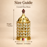 Size guide image of the ASHTOK Crystal Diya Brass displayed on a warm beige background with clear measurement arrows, showing the product height as 7 inches and diameter as 3.5 inches. The image presents the diya upright in the center with a clean product-focused layout, helping customers understand the exact dimensions while also highlighting the polished brass body, crystal stone detailing and decorative star-cut top lid.