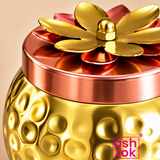 Close-up of ASHTOK decorative dry fruit jar showing glossy hammered finish and detailed copper-tone lotus lid