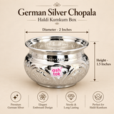 Ashtok German Silver Chopala Haldi Kumkum Box size guide showing the compact traditional silver-finish bowl with clear measurements of approximately 2 inches diameter and 1.5 inches height. The image displays the embossed German silver chopala with its wide polished rim, rounded decorative body, intricate floral pattern and original pink Ashtok branding against a premium beige background. Measurement arrows clearly indicate the product dimensions so customers can understand the actual compact size before pu