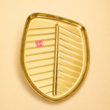 Ashtok golden metal leaf-shaped tray featuring embossed leaf vein texture and a high-shine polished finish.