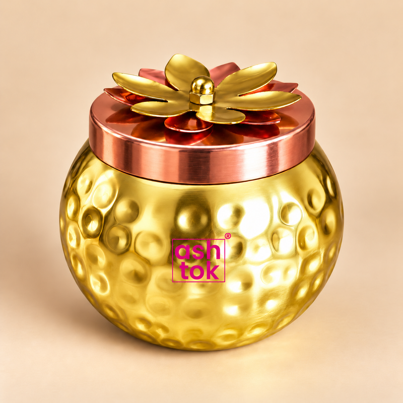 ASHTOK gold-tone hammered dry fruit jar with decorative copper-tone lotus lid on beige background