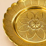 Close-up of ASHTOK gold-tone serving plate showing detailed floral embossing and textured scalloped rim