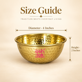 ASHTOK hammered brass bowl size guide showing 4 inch diameter and 2 inch height, featuring a polished golden brass finish, hand-hammered texture, round katori shape and smooth rolled rim for serving, pooja and gifting use.