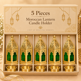 Five piece gift set image of the Ashtok Moroccan Lantern Candle Holder presented inside an elegant premium beige box with individual compartments for each lantern and its corresponding removable candle cup. The box contains five matching Moroccan lanterns in a neat row, each featuring a golden finish, pointed perforated top, circular hanging ring and green glass side panels, with five matching round candle cups placed below. The packaging presentation makes this quantity ideal for festive gifting, return gi