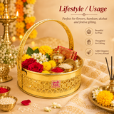 Lifestyle presentation image titled "Lifestyle / Usage" demonstrating the practical application of the Ashtok gold Puja Basket. The basket is arranged with yellow marigolds, white jasmine, red roses, a folded traditional red cloth, and small brass containers for kumkum and akshat. The surrounding background includes a burning brass oil lamp (diya) and incense sticks, with callouts for "Beautiful for Puja", "Thoughtful for Gifting", and "Adds Elegance to Every Ritual".