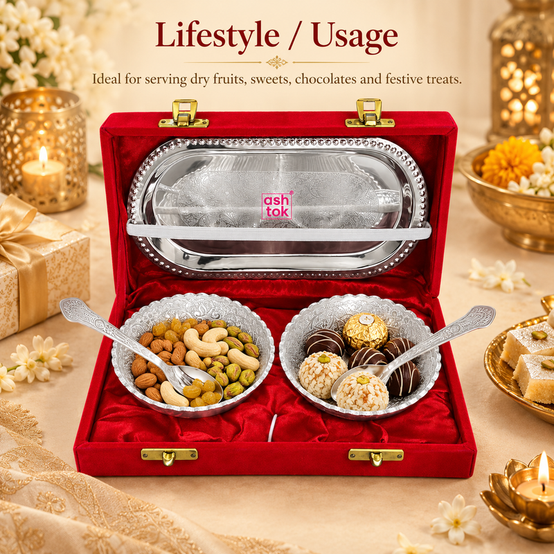 Festive lifestyle display image titled "Lifestyle / Usage" showing the Ashtok silver-plated bowls filled with mixed nuts (almonds, cashews, pistachios, raisins) and festive sweets (laddus and chocolates). The set rests inside its open red velvet gift box surrounded by gold lit diyas, sweets, and gift boxes.