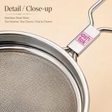 Extreme close-up of the fine mesh wire screen and branded handle joint on an Ashtok stainless steel tea strainer.