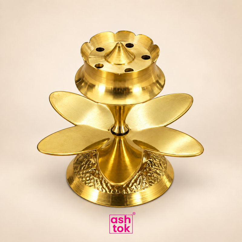 Brass agarbatti stand with lotus-style petal design, multiple incense stick holes and polished brass finish on a beige background.