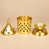 Alt Text:
Brass Akhand Diya displayed in its three separate components, including a removable golden brass conical lid decorated with Swastik symbols and ventilation holes, a cylindrical perforated brass enclosure, and an inner brass oil lamp with a raised central wick holder mounted on a wide circular pedestal base. The detailed product view highlights the construction, polished golden finish, removable components, and traditional craftsmanship of this 7-inch Brass Akhand Deep for home mandirs, everyday wo