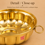 Close-up detail image of the brass bowl showing the reflective polished surface, smooth inner finish, curved scalloped body design and side handle detail, highlighting the craftsmanship and premium traditional appearance of the bowl.