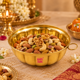 Lifestyle image of a brass bowl styled in an elegant serving setup, showing how the bowl can be used for serving dry fruits, snacks, sweets or festive food items, while emphasizing its traditional Indian look and rich polished brass finish.