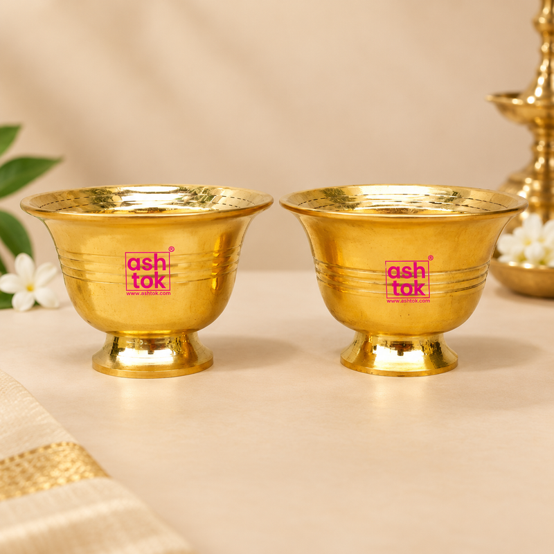 Brass Chandan Bowl with a polished golden finish, flared rim, rounded body, subtle horizontal ring detailing and sturdy pedestal base, professionally presented as a matching pair on a premium beige studio background for puja and traditional use.