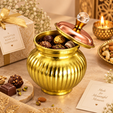 Features image of a decorative brass and copper gift box on a warm beige background, highlighting the crystal-style top knob, contrasting copper-toned lid, vertically ribbed polished brass body and suitability for chocolates, dry fruits and gift items, with detailed feature callouts designed to showcase the elegant metal finish, traditional rounded container shape and premium decorative styling for festive gifting, weddings, housewarming occasions and special celebrations.