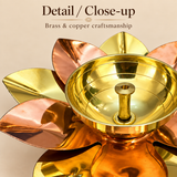 Close-up detail image of a brass and copper lotus diya on a beige background, focusing on the polished metal finish, smooth handcrafted bowl, neatly shaped central wick holder, and alternating copper and brass lotus petals, allowing customers to see the craftsmanship, shine, material finish, and intricate design details of this akhand diya used for traditional décor, gifting, and festive display.