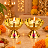 Traditional brass diyas shown lit with warm flames in a festive pooja setting surrounded by marigold flowers and devotional decor, demonstrating their use for Diwali, aarti, home temple rituals and daily worship.
