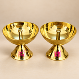 Brass diya for pooja featuring a polished golden bowl, central wick holder and stable pedestal base, presented as a matching pair on a premium beige studio background for Diwali, daily worship and traditional home temple use.