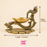 Brass diya with peacock handle shown with size guide, measuring 4 inches in height and 6 inches in length, suitable for pooja and festive use.