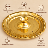 Product features infographic showcasing a decorative brass diya with attached plate featuring a wide circular brass thali, central raised oil lamp cup, polished golden finish, intricate engraved surface patterns and a decorative beaded rim. The traditional design combines a diya holder and pooja plate in one piece, making it suitable for daily worship, Diwali lighting, aarti ceremonies, temple rituals and traditional religious celebrations.