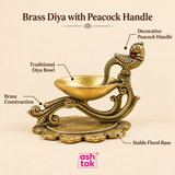Brass diya with decorative peacock handle, traditional diya bowl, detailed brass construction and stable floral base.