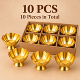 Set of 10 decorative brass lotus flower bowls featuring polished golden surfaces, raised floral petals, scalloped rims and pedestal bases. The image shows multiple brass bowls arranged in a simple brown cardboard box with individual compartments, along with additional pieces displayed outside the packaging. Suitable for wedding return gifts, festive celebrations, religious ceremonies, bulk gifting and decorative flower arrangements.