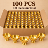 Bulk pack of 100 traditional brass lotus flower bowls featuring polished golden finishes, elegant scalloped flower-shaped rims, textured inner bases and circular pedestal stands. The bowls are displayed in neatly arranged rows inside a large open brown corrugated cardboard box, with five individual bowls placed in front to highlight the product design. Suitable for wholesale orders, wedding return gifts, festive gifting, religious functions and bulk decorative requirements.