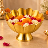 Traditional brass lotus flower bowl displayed in an elegant festive setting and filled with fresh orange marigold flowers, white blossoms and red rose petals. The decorative golden brass bowl features beautifully curved lotus petals and a raised pedestal base, surrounded by warm decorative lighting and traditional brass accessories. Suitable for pooja flower offerings, festive home decoration, Diwali arrangements and religious celebrations.