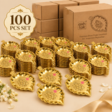 Bulk presentation of 100 brass Ganesh leaf trays with multiple decorative trays arranged in front of plain packaging boxes, suitable for wholesale orders, wedding return gifts, festive distribution and large religious functions.