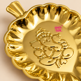 Detailed close-up of brass leaf tray highlighting the embossed Ganesh motif, polished golden surface, scalloped decorative rim, leaf-shaped outline and fine raised detailing of the traditional brass plate.